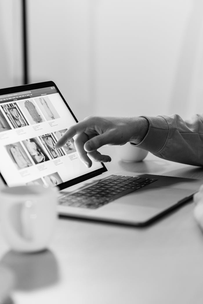 gallery-05 Black and white photo of a person shopping online on a laptop, highlighting e-commerce technology.